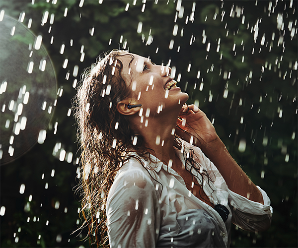 woman in the rain wearing earbuds