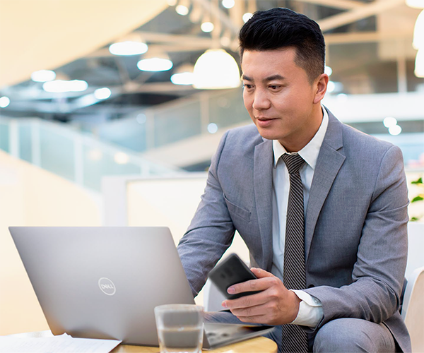 business man sitting with Dell laptop