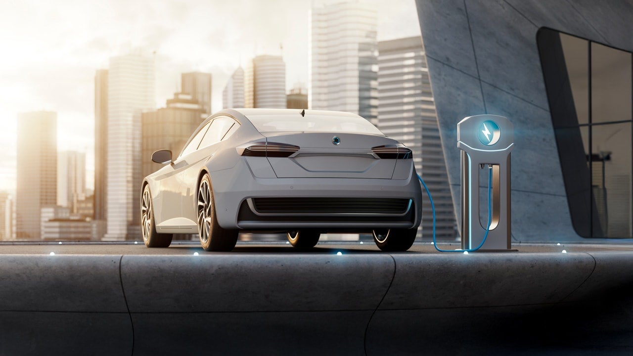 近代的な都市を背景に充電するEV