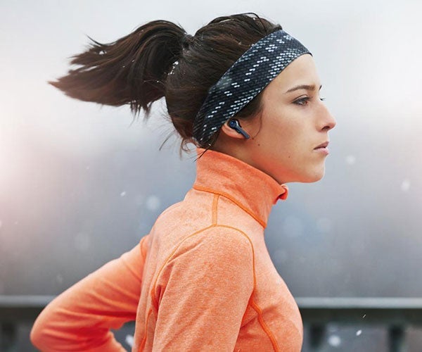 woman running with earbuds in her ears