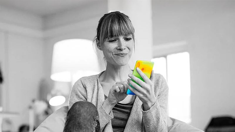 熱分布が可視化されたスマートフォンを操作しながら微笑む女性