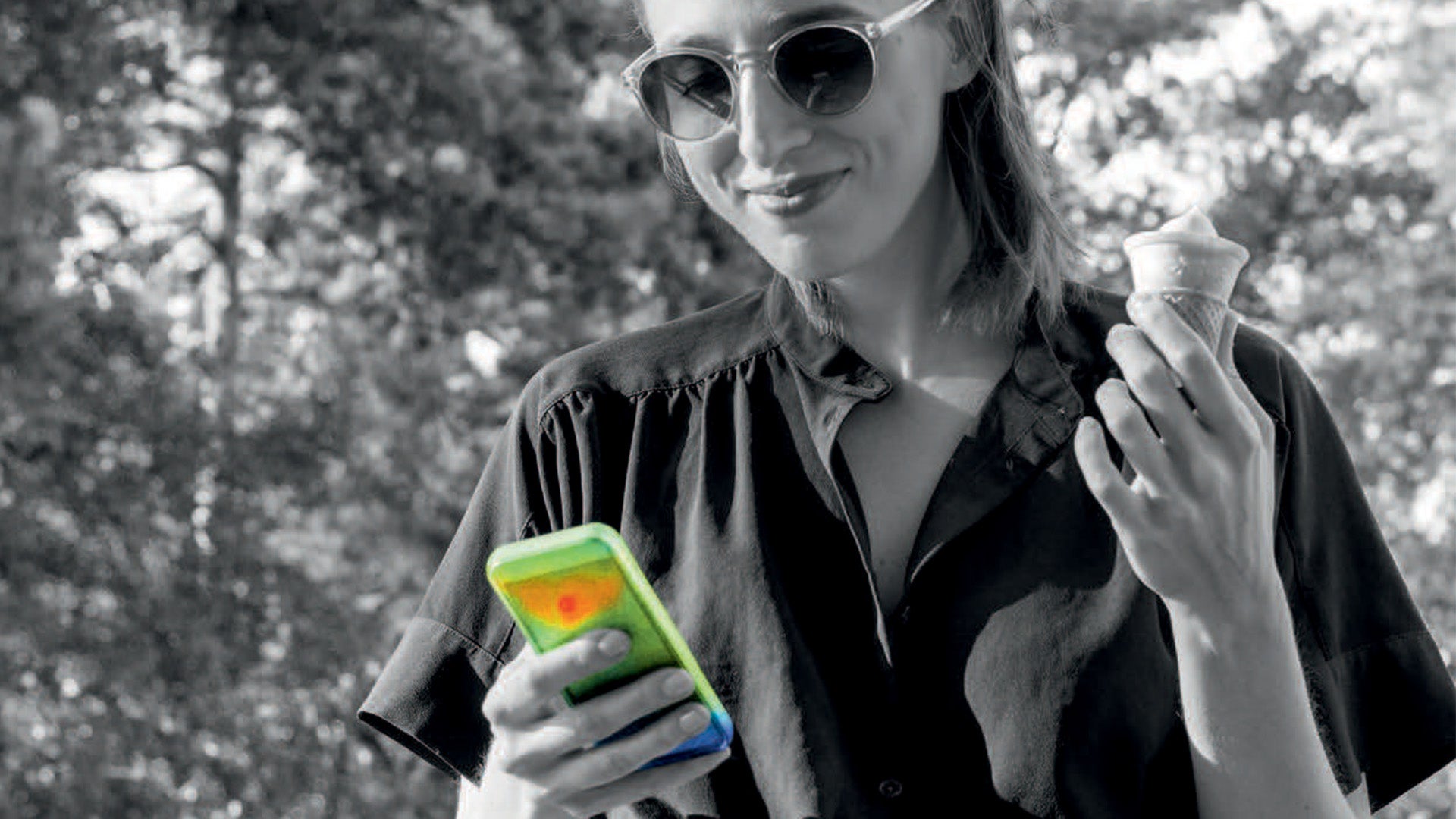 アイスクリームを手にスマートフォンを見る女性
