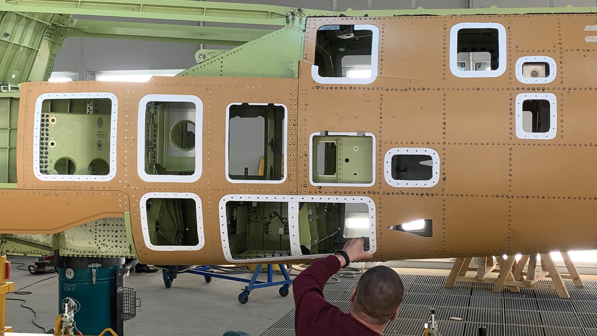 アクセスパネルが開いた航空機の胴体部で、技術者がパネルフレーム周囲にSKYFLEXシーリング材を施工している様子