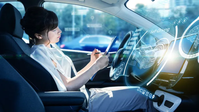 自動運転車でタブレットを操作する女性