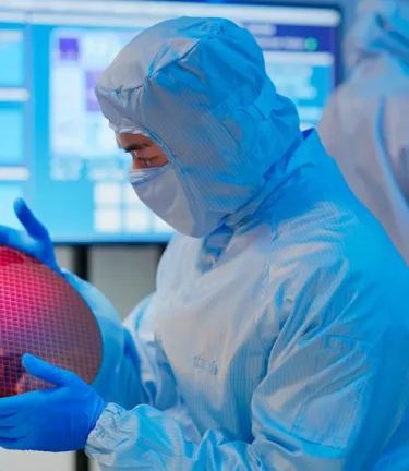 Technician using PPE in a clean environment.