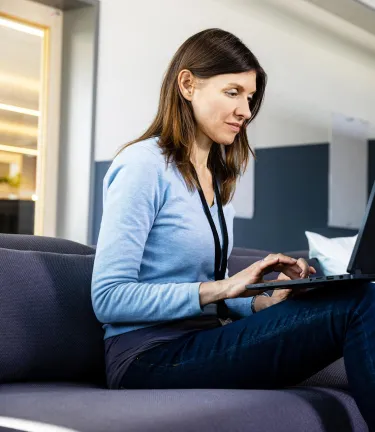 associate working on her laptop in an open office space