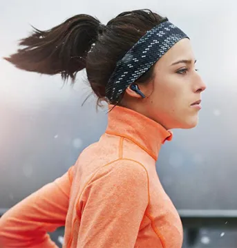 Woman running with earbuds.