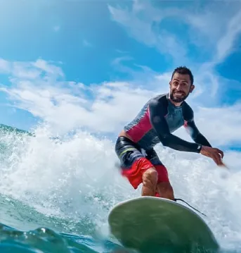 Man on a surfboard catching a wave.