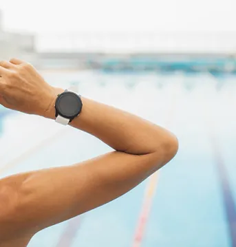 swimmer putting goggles on with smartwatch on her wrist