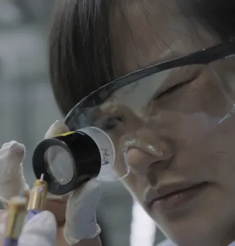 Woman examing a cable while wearing PPE.